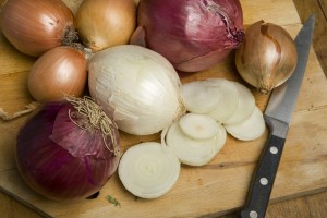 Various different types of onion on a chopping board